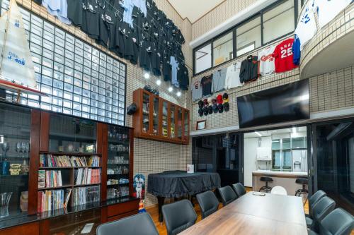 a dining room with a table and chairs and a tv at 最大20名宿泊可能 大型テレビでスポーツ観戦 グループ旅行に最適 KOEI HOUSE in AWASE in Okinawa City