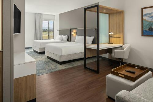 a hotel room with two beds and a desk at SpringHill Suites by Marriott Kalispell in Kalispell