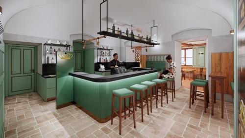 a bar with green cabinets and a man and a woman at SPA Hotel Erzherzog Johann in Bad Aussee