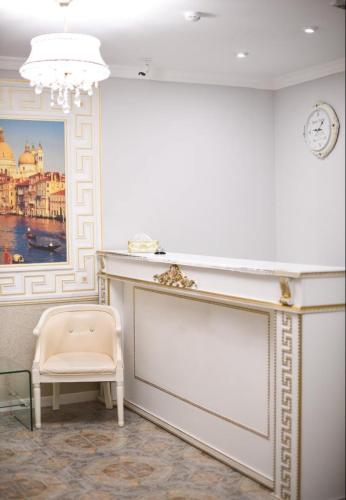 a white room with a chair and a clock at Sky luxe-hotel Astana in Astana