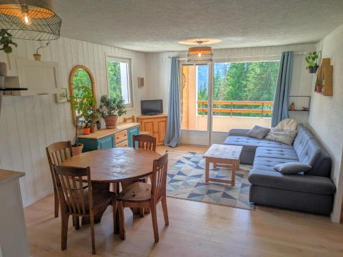 un salon avec un canapé et une table dans l'établissement Grand Appartement, 2 Chambres, à Arâches-la-Frasse