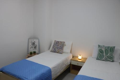 ein Schlafzimmer mit 2 Betten und einer Lampe auf einem Tisch in der Unterkunft Casa Maria in Santa Cesarea Terme