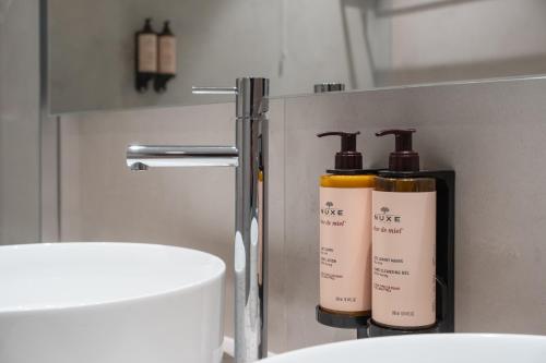 two bottles ofodorizers sitting on a counter in a bathroom at Mercure Ponta Delgada Azores in Ponta Delgada