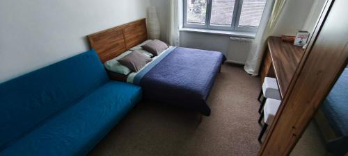 a room with a blue couch and a bed at ROOM IN TREBON in Třeboň