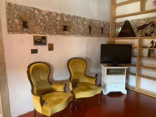 two chairs in a living room with a television at Corte 40 Rooms in Negrar