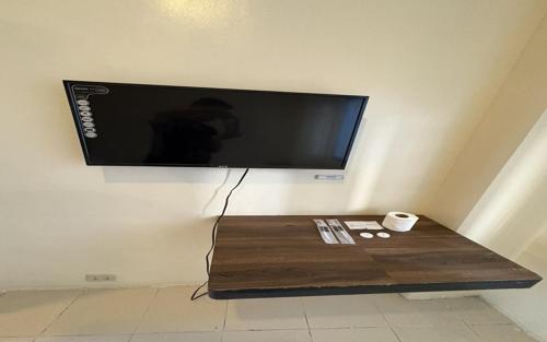 a flat screen tv on a wall with a coffee table at San Antonio's Place Suites in Manila