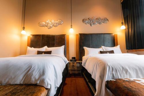 a hotel room with two beds with white sheets at The Iron Horse Hotel in Milwaukee