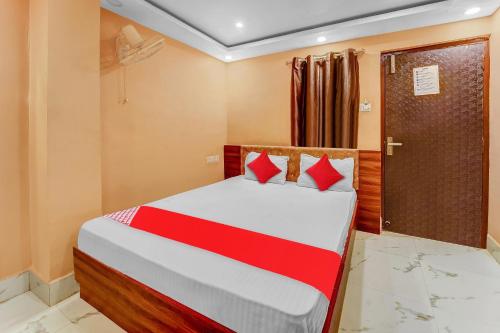 a bedroom with a bed with red pillows at Hotel O Bhagirathi Palace in Tapovan
