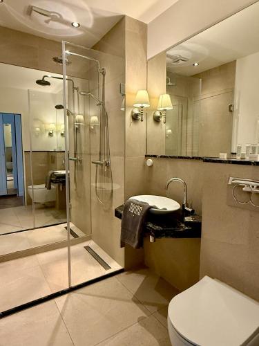 a bathroom with a shower and a toilet and a sink at Twins Hotel in Duisburg