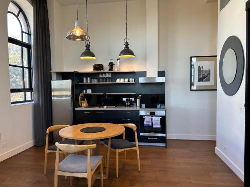 a kitchen with a table and chairs in a room at THE DEVLIN APARTMENTS 2 Bedroom Apartment near GMHBA stadium in Geelong - 108 in Geelong