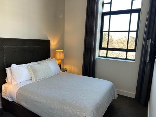 a bedroom with a bed with a large window at THE DEVLIN APARTMENTS 2 Bedroom Apartment near GMHBA stadium in Geelong - 108 in Geelong