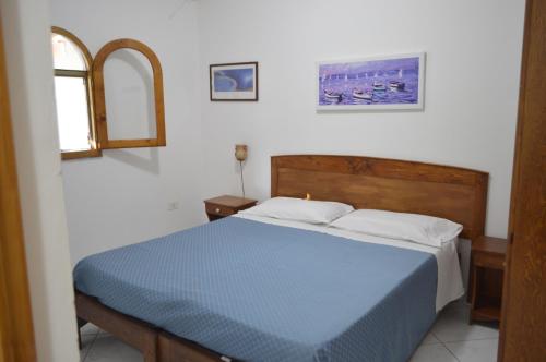 a bedroom with a blue bed and two windows at Le Anfore Villette in Lampedusa