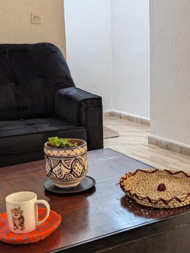 a coffee table with a cup and a pie and a chair at Beach House - Tamraght, Aourir in Aourir