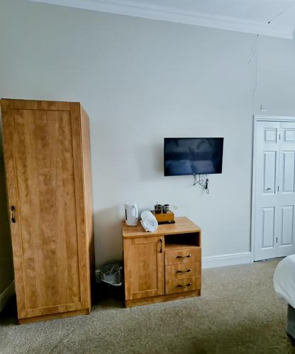 a room with a door and a table and a tv at The Coach House in Otterburn
