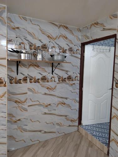 a room with a door and a wall with pots and pans at Beach House - Tamraght, Aourir in Aourir