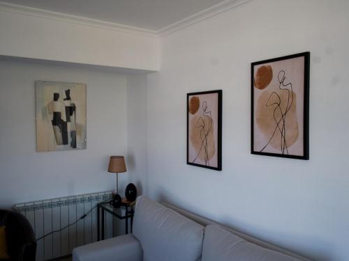 a living room with a couch and two pictures on the wall at Chancelas b in Combarro