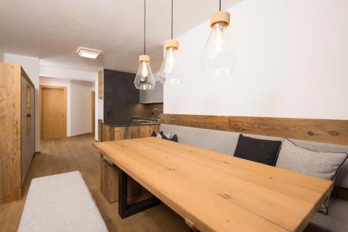 a kitchen with a wooden table and some lights at Appartements Huber in Fügen
