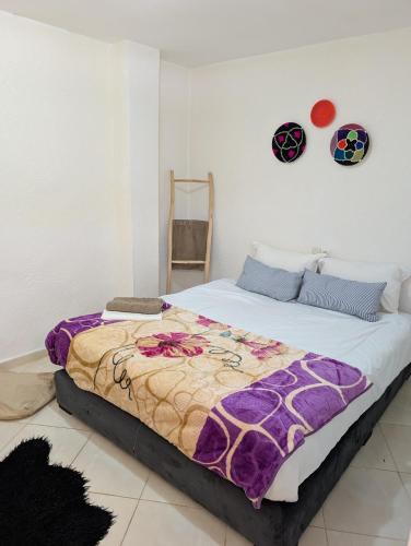 a bedroom with a bed with a blanket on it at Beach House - Tamraght, Aourir in Aourir