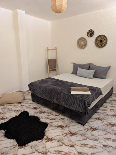 a bedroom with a bed with a black blanket at Beach House - Tamraght, Aourir in Aourir