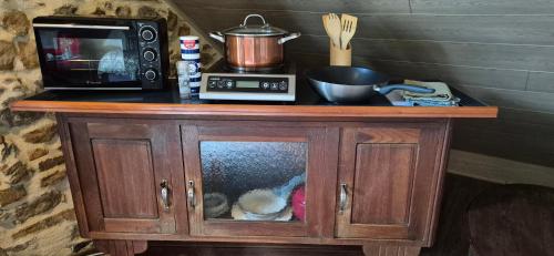 d'une petite armoire en bois avec un four micro-ondes. dans l'établissement unique room with great view in a former old barn, à Troche