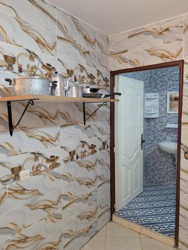 a bathroom with a door open to a bathroom with a shower at Beach House - Tamraght, Aourir in Aourir