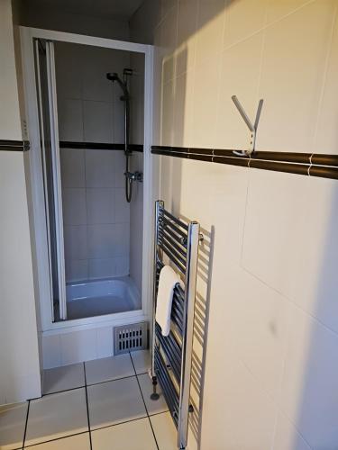 a bathroom with a shower and a towel rack at The Coach House in Otterburn