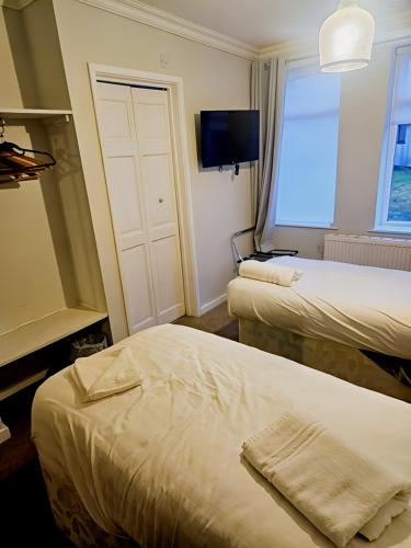a hotel room with two beds and a tv at The Coach House in Otterburn