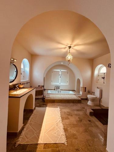 a bathroom with a tub and a toilet in a room at Evasion champetre à El Monchar Hammamet in Hammamet