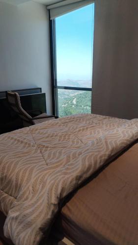 a bed in a room with a large window at AlFahed Farm in Ajloun