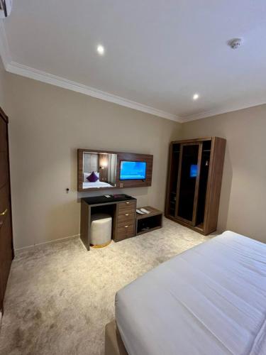 a bedroom with a bed and a desk and a television at لافانتا للشقق المخدومه - LAVANTA Hotel in Al Khobar