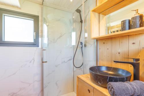 une salle de bain avec douche et lavabo dans l'établissement Tiny house Pitta, à Les Alliés
