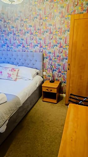 a bedroom with a bed and a table with a lamp at The Coach House in Otterburn