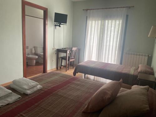 a hotel room with two beds and a desk with a mirror at Hotel Seva in Seva