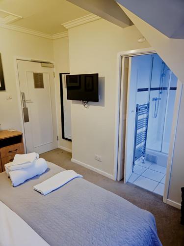 a bedroom with a bed with a tv on the wall at The Coach House in Otterburn