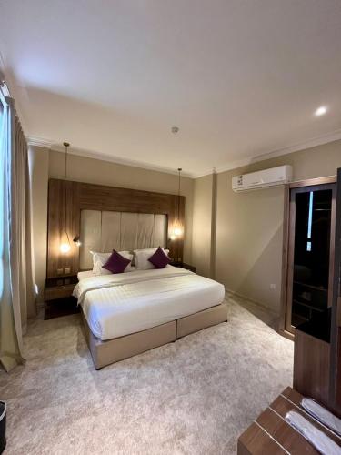 a bedroom with a large white bed in a room at لافانتا للشقق المخدومه - LAVANTA Hotel in Al Khobar