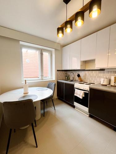 a kitchen with a table and a table and chairs at Kotimaailma Aparthotel Ankkuri - 4 Bedroom in Kotka