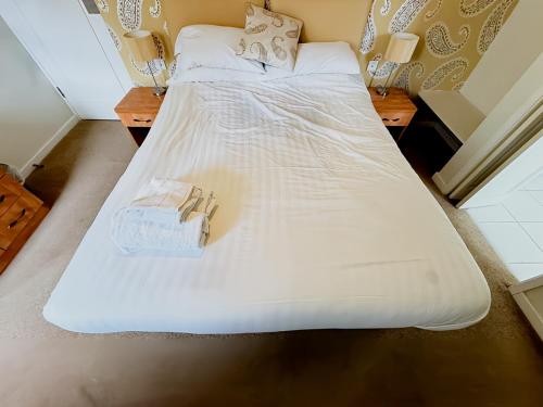 a bedroom with two beds with white sheets and two napkins at The Coach House in Otterburn