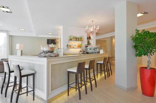 a bar with a bunch of stools in a room at Hotel Fiamma & SPA Cesenatico in Cesenatico