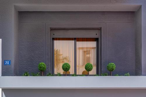 a window with three trees on a balcony at Athens Meli in Athens