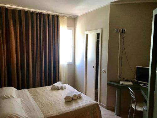 a hotel room with a bed with towels on it at Hotel Fiamma & SPA Cesenatico in Cesenatico