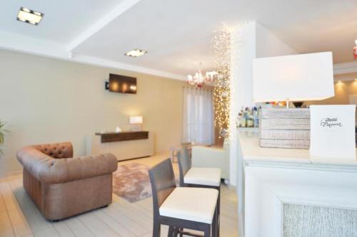 a living room with a couch and chairs and a fireplace at Hotel Fiamma & SPA Cesenatico in Cesenatico