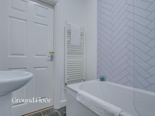 a white bathroom with a tub and a sink at Inviting 2-Bed apartments - Perfect for Contractors & Business Travellers Parking - Wi-Fi - Netflix in Retford