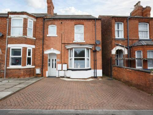 an old brick building with a white door at Inviting 2-Bed apartments - Perfect for Contractors & Business Travellers Parking - Wi-Fi - Netflix in Retford