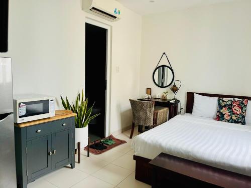 a bedroom with a bed and a tv and a desk at Moonlight House & Apartment Nha Trang in Nha Trang
