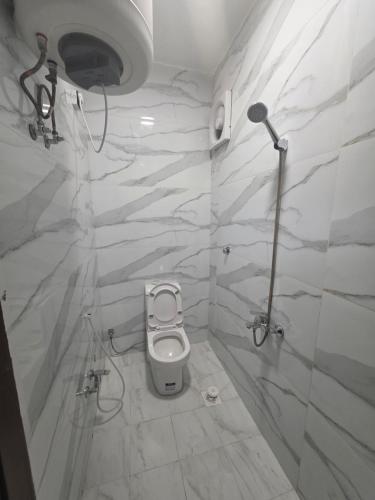 a white bathroom with a toilet and a shower at منازل بريدة للشقق المفروشة in Buraydah