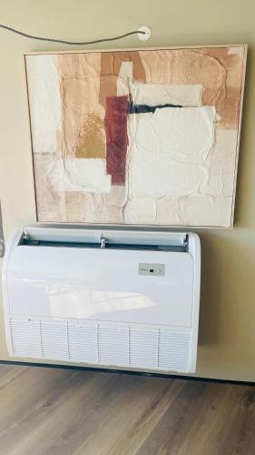 a white heater sitting on a wall with a painting at 903 by the sea in Sesimbra