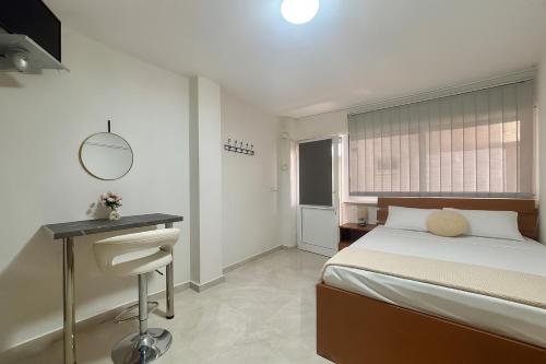 a bedroom with a bed and a desk and a mirror at Athena studio in Orfánion