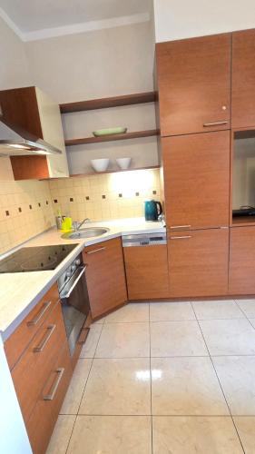 a kitchen with wooden cabinets and a sink at Józefina Apartament's blisko centrum in Szklarska Poręba