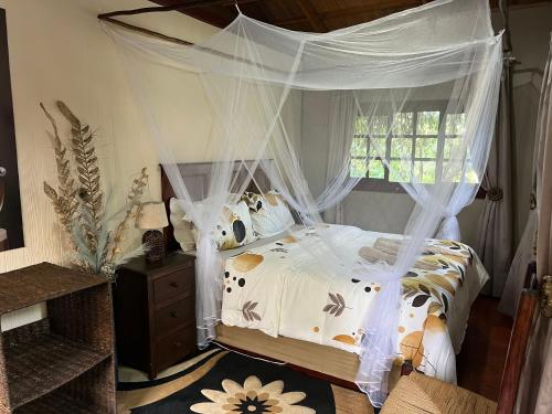 a bedroom with a bed with a canopy at Moz Inn - Coconut View Resort in Lopes