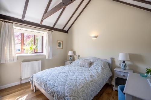 a bedroom with a bed and a window at Canute Cottages - Cullimers Cottage in Chidham